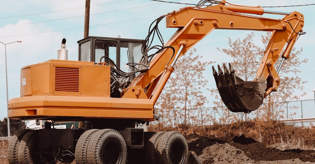 A yellow excavator at a rural construction site, ready for operation.
