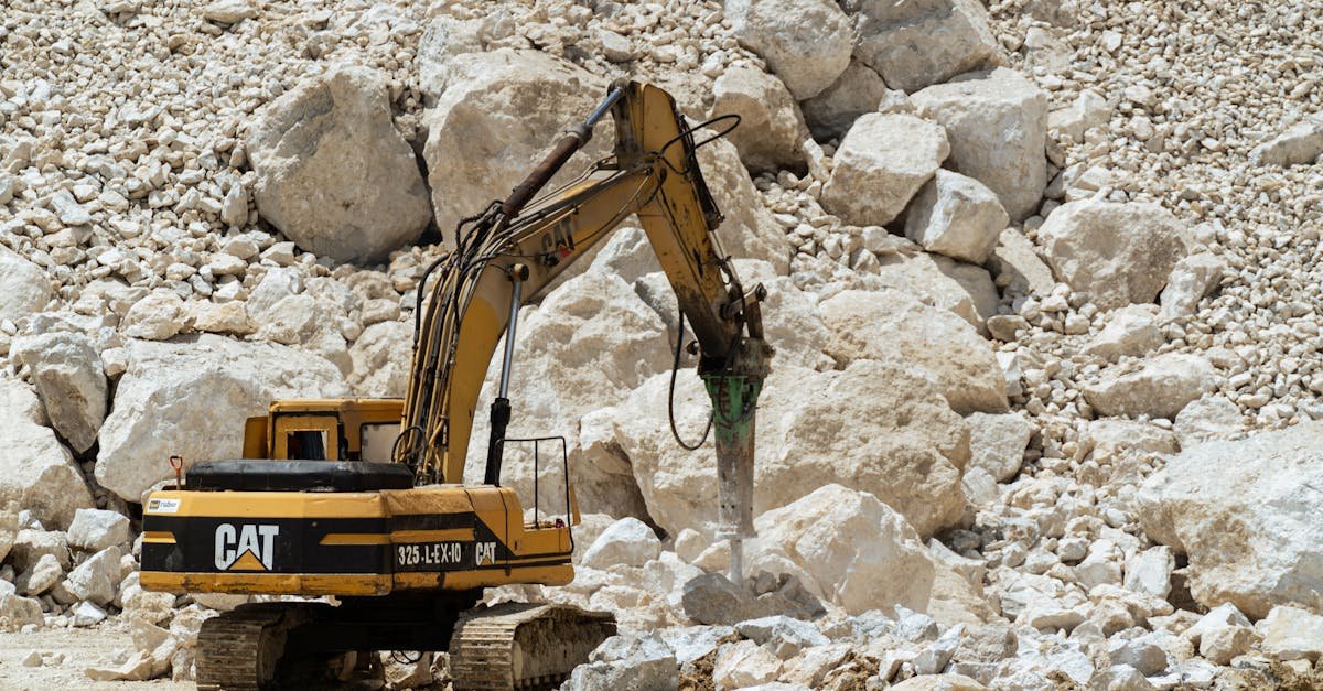 Excavator breaking rocks in a quarry, showcasing heavy-duty industrial work.